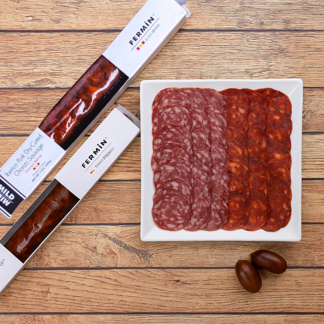 Fermin salami and pepperoni on a wooden surface with packaging.