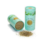 Two teal cylindrical containers of 'Sál de Ibiza' with dried herbs spilling out on a white background.