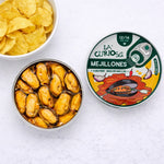 Can of mejillones with a bowl of chips on a white background