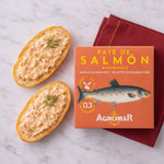 Two slices of bread with smoked salmon pate and a box of Agromar smoked salmon pate on a marble surface.