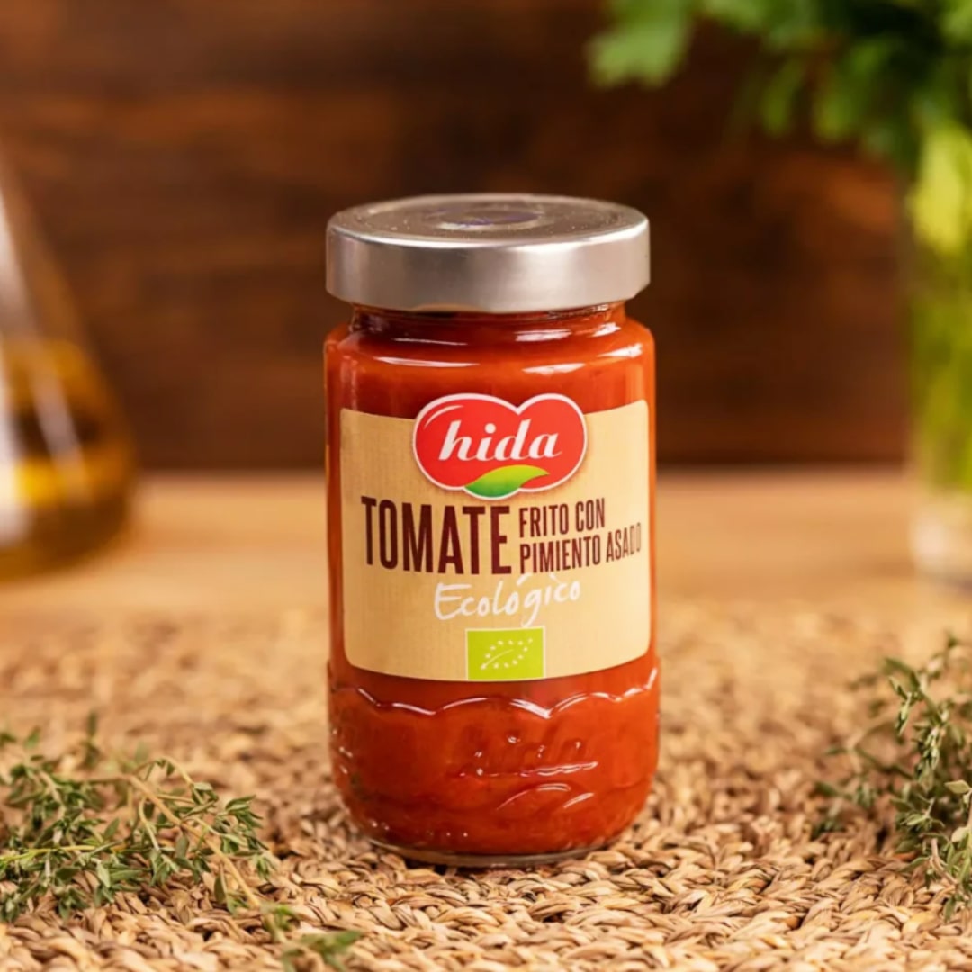 A jar of Hida brand Organic Piquillo Peppers in Tomato Sauce, with the label showing the product name and the word 'Ecológico' indicating it is organic.