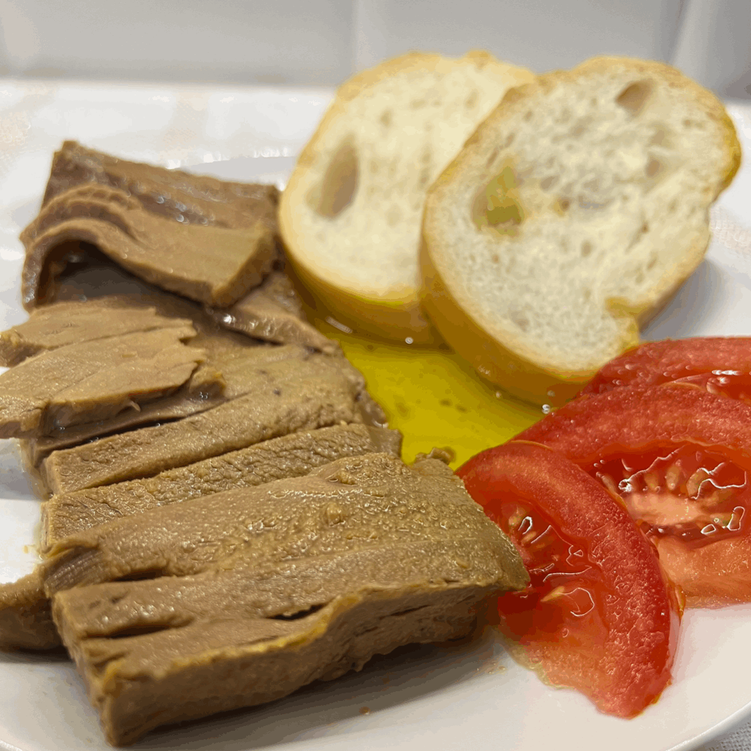 pieces of Red Tuna El Ronqueo with sliced tomato and bread