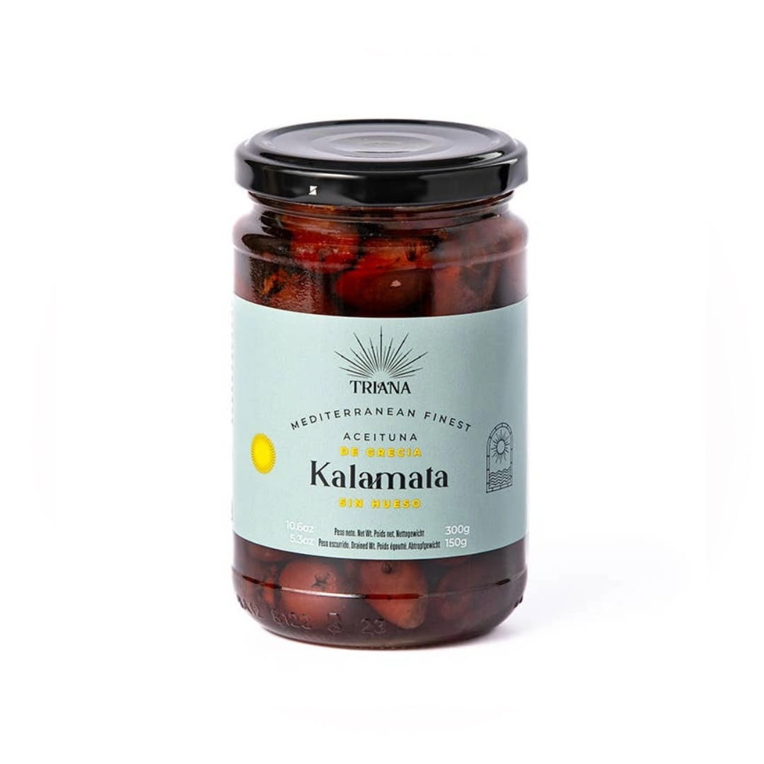 A glass jar of Triana Kalamata olives, with a light blue label and a black lid, set against a plain white background.