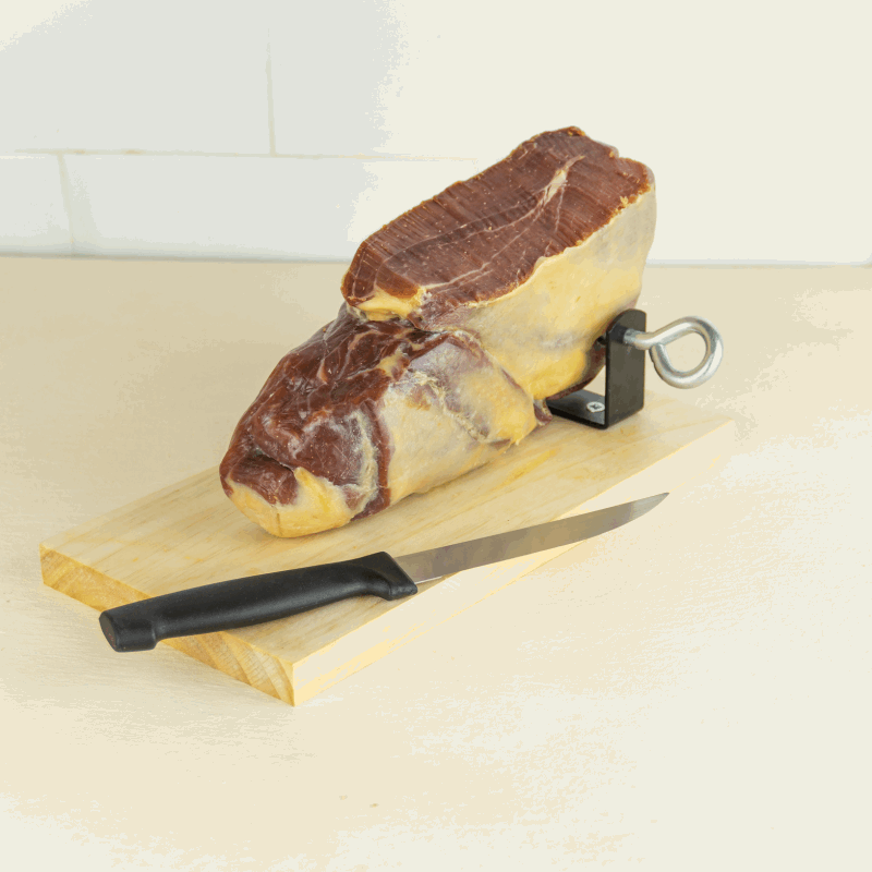 a piece of ham on a ham holder and a knife