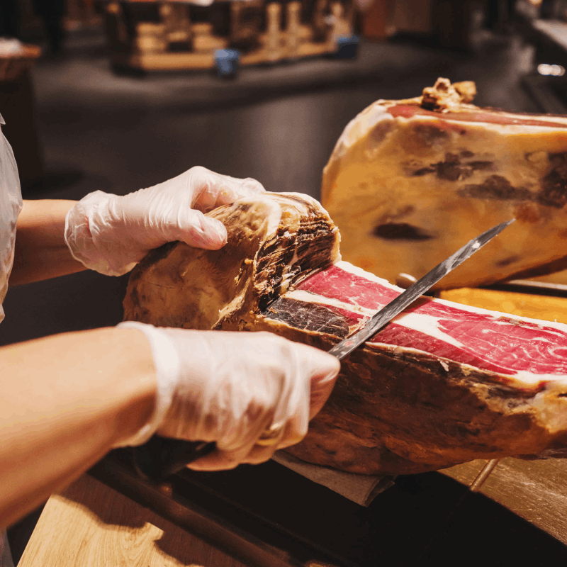 an Iberian ham bone-in being cutting by someone