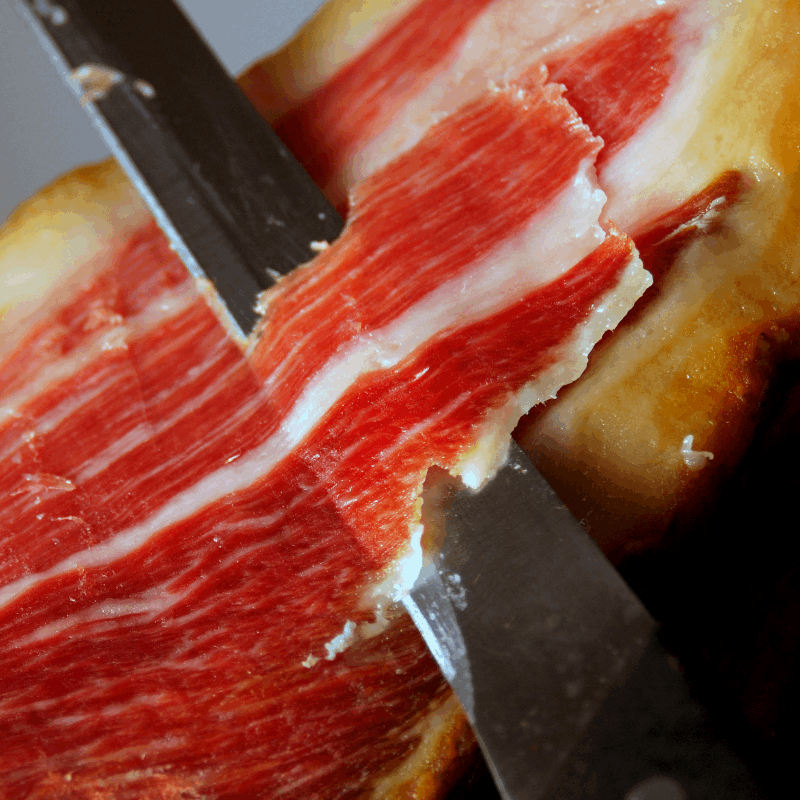 knife getting a slice of Iberian ham