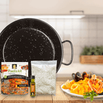 A paella pan with paella kit and rice and a plate of paella