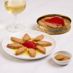 Canned tuna with pimiento on a plate with a glass of white wine and cookies.