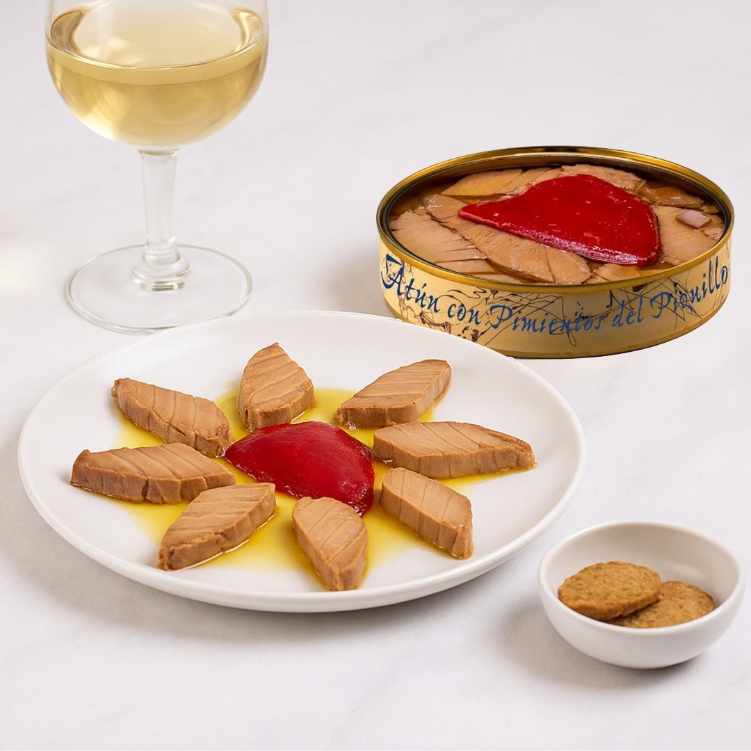 Canned tuna with pimiento on a plate with a glass of white wine and cookies.