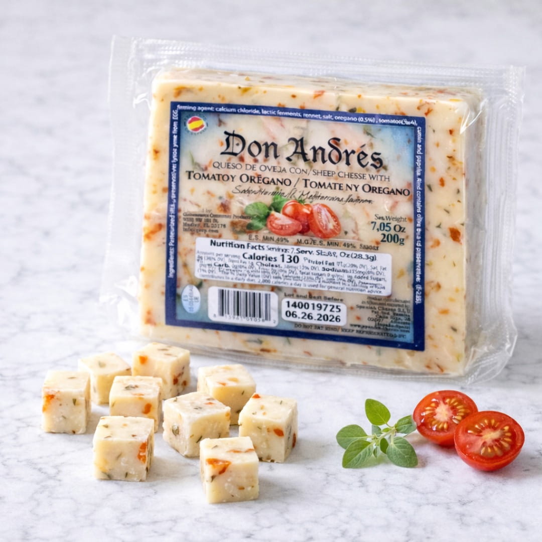 Packaged cheese with 'Don Andres' label on a white surface with sliced tomatoes and cheese cubes.