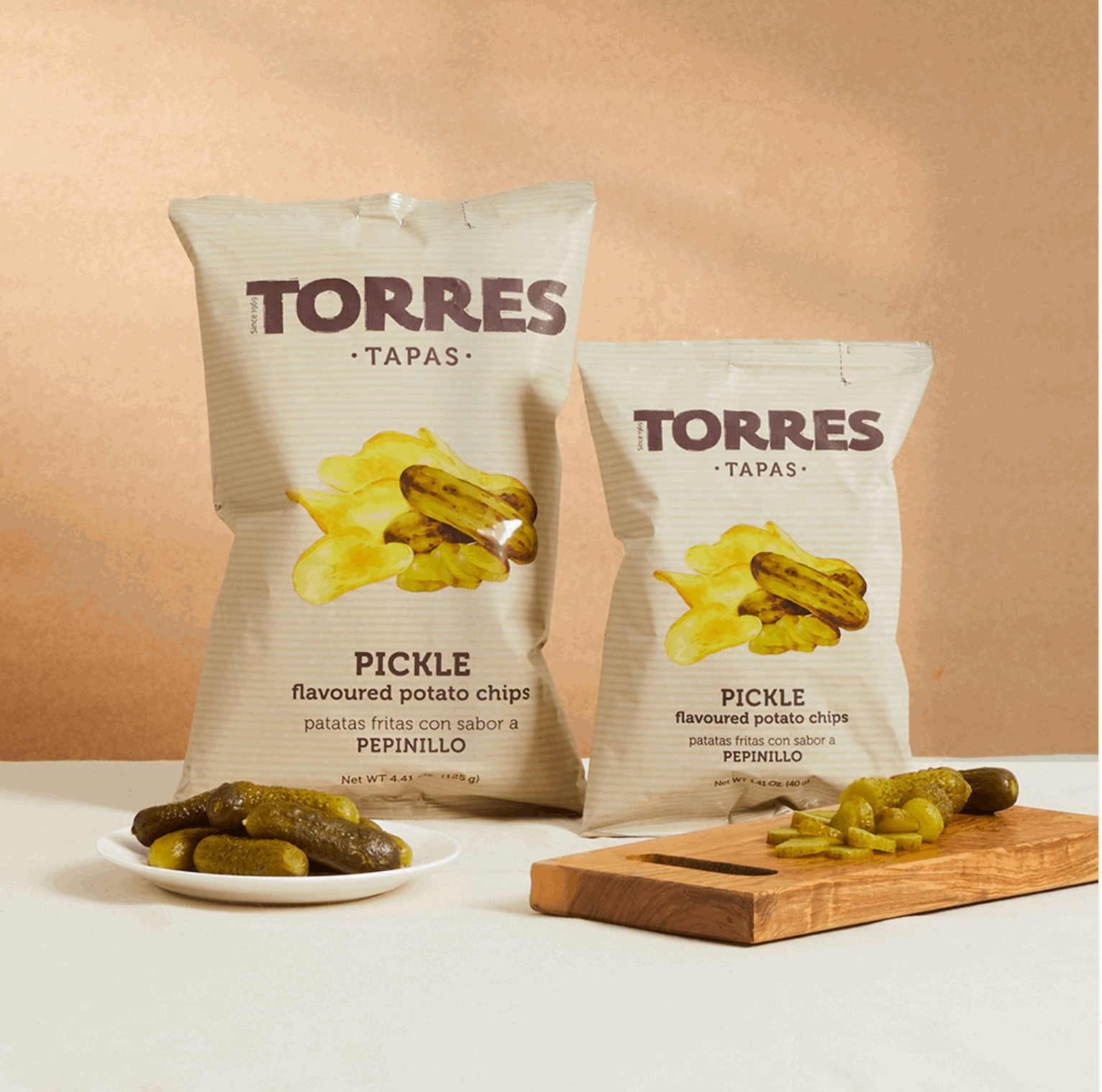 two package of torres pickle chips and some pickles on a table