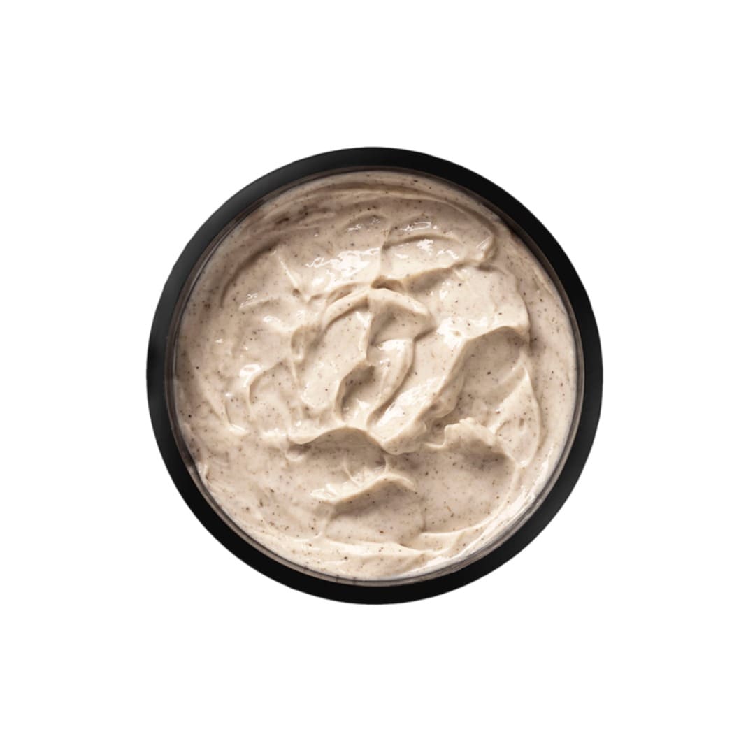 Black bowl filled with a creamy beige substance on a white background