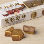 Turrón Bombon Rocher chocolate bars with packaging on a wooden surface