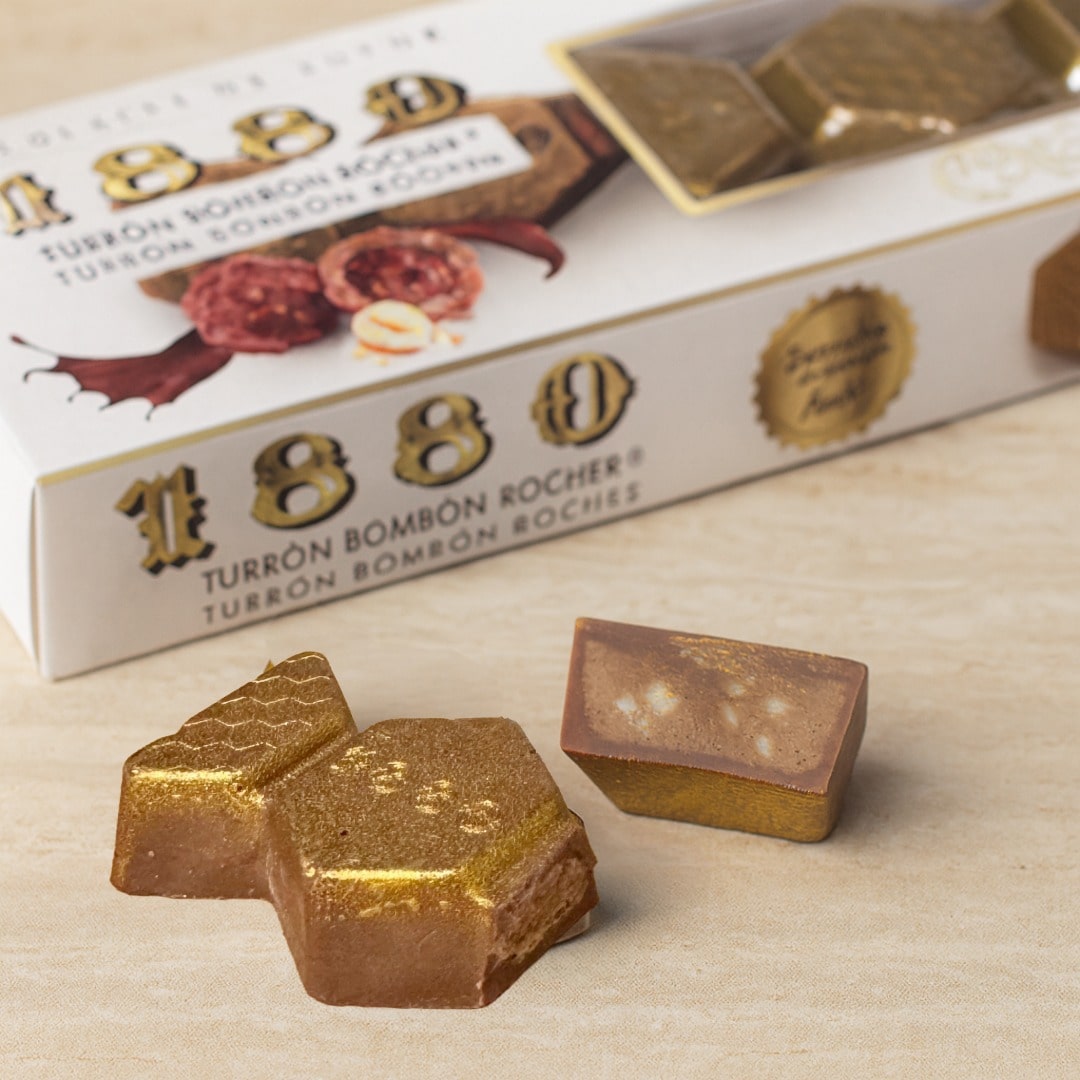 Turrón Bombon Rocher chocolate bars with packaging on a wooden surface